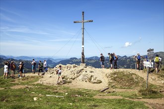 Hiker at the summit cross at Riedberger Horn