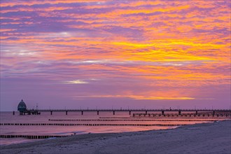 Groyne and diving gondola with pier at the beach of Zingst at sunrise