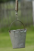 Dented metal bucket on wellstick