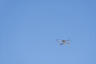 Drone flies in front of blue sky