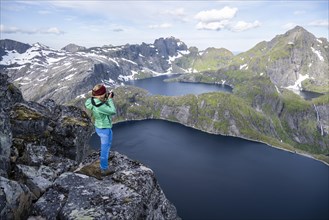Young woman looking over mountain landscape with lake Tennesvatnet