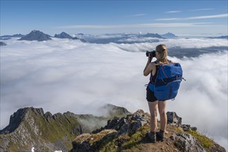 Hiker looking over mountain landscape in fog