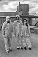 People in protective suits and wearing gas masks demonstrate in front of the former nuclear power plant Wuergassen