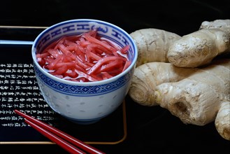 Pickled ginger in small bowls and ginger root