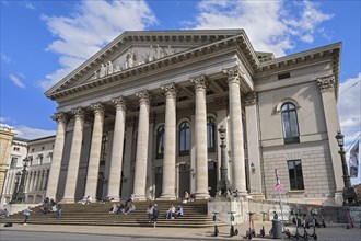 People sunbathing on the stairs in front of the opera