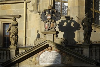 Tympanum or gable above the entrance of the town hall with statues and town coat of arms