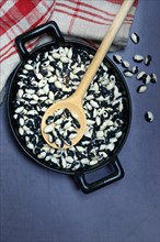 Dried bush beans in pot with cooking spoon