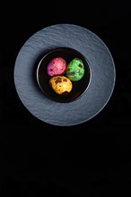 Coloured quail eggs in small bowls