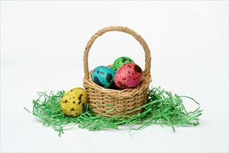 Coloured quail eggs in baskets