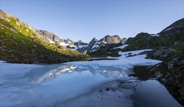 Mountains reflected in the lake Isvatnet with ice