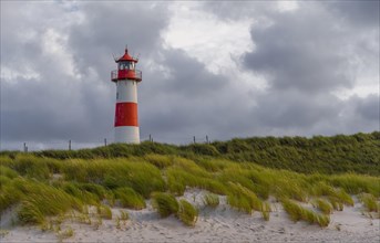 Red-white lighthouse List-Ost in the dunes in front of cloudy sky