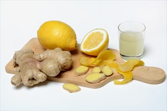 Ginger root and lemon on wooden board and glass of ginger lemon juice