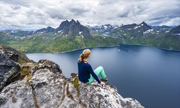 Young hiker sitting on cliff