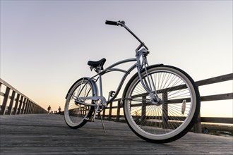 New vintage bike parked in the middle of the wooden boardwalk at sunset in Portugal