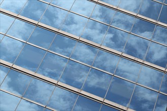 Glas facade with reflection of blue sky and clouds on a business building in Ginza district