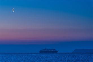 View of cruise ferry and moon during the blue hour in Torquay