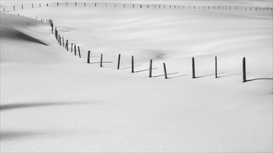 Fence in snowy meadow