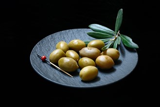 Greek olives from Chalkidiki on plate with toothpick