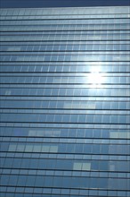Glas facade of a business building with reflecting sun in Ginza district