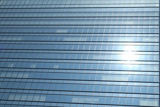 Glas facade of a business building with reflecting sun in Ginza district