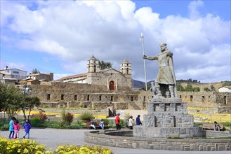 Statue of the Inca Pachacutec in front of sun temple with attached cathedral from the colonial period