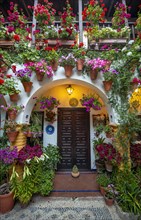 Entrance door and archway in courtyard decorated with flowers