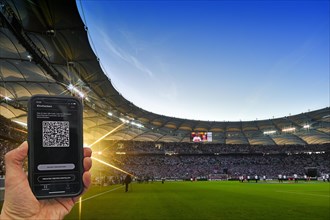 Hand holds smartphone with Luca app for digital contact tracking in packed football stadium