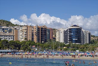 Holidaymakers in front of high-rise buildings in the water and on the beach of Cala Finestrat