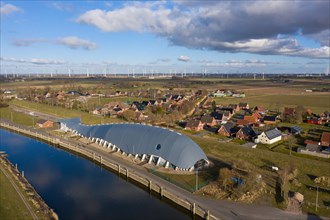 Aerial view of Friedrichskoog Rugenort with view of the indoor playground Willi and the Rugenort Loch in sunlight