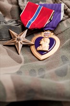 Bronze and purple heart medals on camouflage material