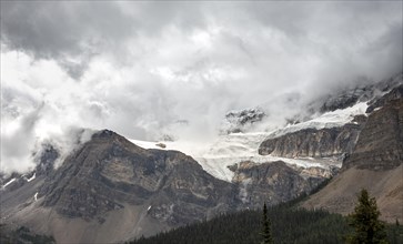 Snowy mountain peaks and glaciers covered with clouds