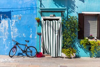 Bicycle in front of a blue house
