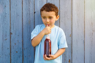 Child little boy drinking cola lemonade drinking bottle