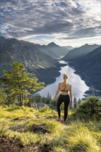 Hiker in sport clothes looking at Plansee