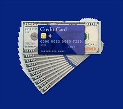 Mockup blue credit card resting on one hundred dollar bills on blue background