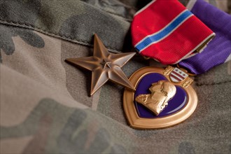 Bronze and purple heart medals on camouflage material