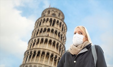 Young Woman Wearing Face Mask Walks Near The Leaning Tower of Pisa In Italy