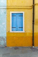 Yellow house with blue window