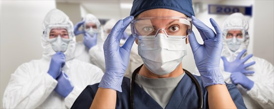 Team of female and male doctors or nurses wearing personal protective wquiment in hospital hallway