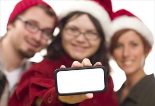 Girl with friends and santa hats holding blank white smart phone