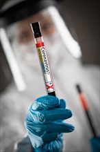 Female Doctor or Nurse Holding Test Tube of Blood Labeled Positive for Coronavirus COVID-19 Disease
