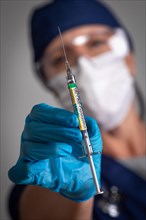 Doctor or nurse holding medical syringe with coronavirus COVID-19 vaccine label