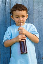 Child little boy drinking cola lemonade drinking bottle