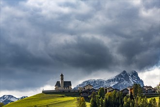 Church of Colle Santa Lucia with snowy mountain peak in the background
