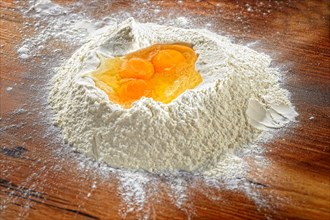 Flour with eggs on wooden table