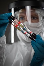 Female Lab Worker Holds Test Tubes of Blood Labeled Coronavirus COVID-19 Disease