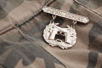 Pistol expert war medal on a camouflage background