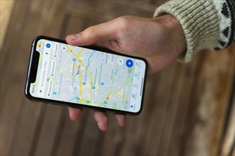 Hand haelt iPhone 11 Pro mit Google Maps App