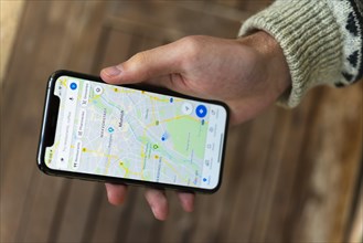 Hand haelt iPhone 11 Pro mit Google Maps App