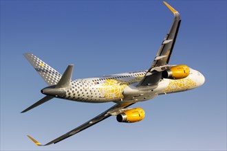 A Vueling Airbus A320 with the registration EC-MNZ and the Vueling Loves Barcelona special livery takes off from Barcelona Airport